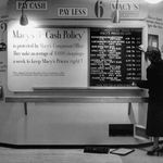 "Macy's department store employee changing the bulletin board's list price as a result of comparison shopping."